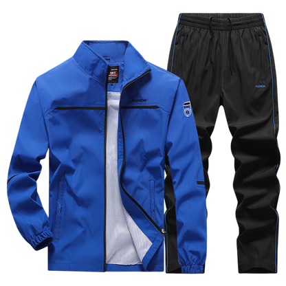 Dres komplet męski dwuczęściowy Arkadya Outlet: bluza na zamek w żywym niebieskim kolorze z czarnymi akcentami oraz czarne spodnie z niebieskimi lampasami i elastycznym pasem.