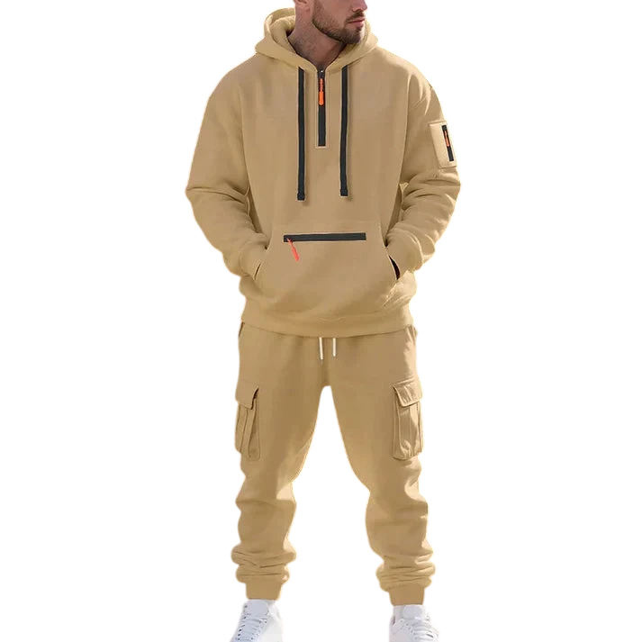 Mężczyzna noszący Arkadya Outlet Męski dres wyściełane wnętrze dwuczęściowy komplet z zamkiem stoi przy dużej, okrągłej parkowej fontannie, ręce w kieszeniach, spoglądając w bok na drzewa i zieleń tworzące spokojne tło.