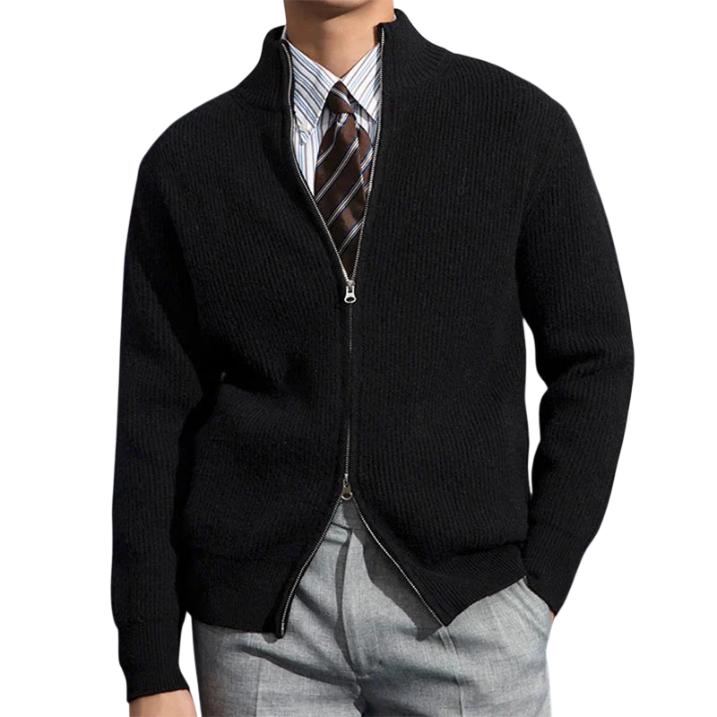 Przed ciemnoniebieską ścianą ozdobioną mapami stoi mężczyzna ubrany w kurtkę Męski Outlet Zapinany Na Zamek Błyskawiczny Dopasowany Krój, koszulę w paski i brązowy krawat oraz jasnoszare spodnie.