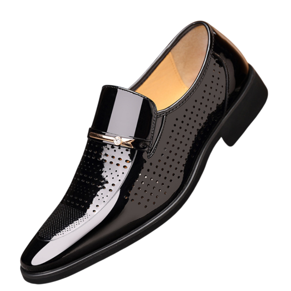 Arkadya Outlet Mokasyny Wizytowe Męskie Wsuwany Szpiczasty Nosek to błyszczący czarny loafers z perforowanymi detalami, metalowym akcentem, niskim czarnym obcasem, beżową podszewką i eleganckim polerowanym wykończeniem.