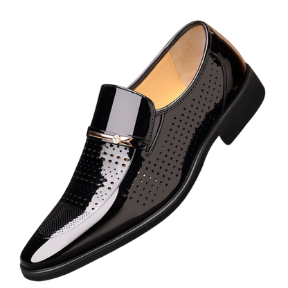 Arkadya Outlet Mokasyny Wizytowe Męskie Wsuwany Szpiczasty Nosek to błyszczący czarny loafers z perforowanymi detalami, metalowym akcentem, niskim czarnym obcasem, beżową podszewką i eleganckim polerowanym wykończeniem.