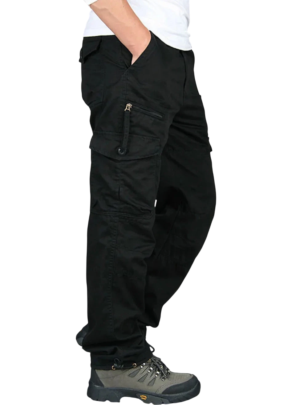 Mężczyzna ubrany w Arkadya Outlet Spodnie cargo męskie prosta nogawka z kieszeniami i zamkiem, białą koszulę i szare buty turystyczne, stojący z jedną ręką w kieszeni na białym tle.