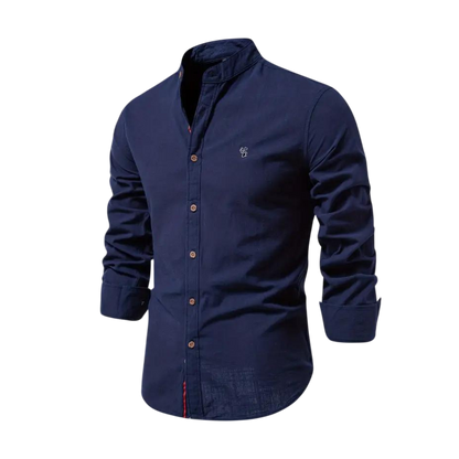 Arkadya Outlet Koszula męska kołnierz stójka długi rękaw krój regularny pokazana jest z podwiniętymi rękawami i zapinanym przodem, idealna do codziennego użytku, prezentowana na manekinie w rozmytym wnętrzu.