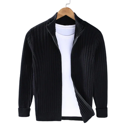 Arkadya Outlet Kardigan Męski Dzianinowy Prążkowana Faktura Zamek Długi Rękaw w kolorze czarnym jest prezentowany na wieszaku na zwykłej białej koszulce, częściowo rozpiętej, na jasnoszarym tle.