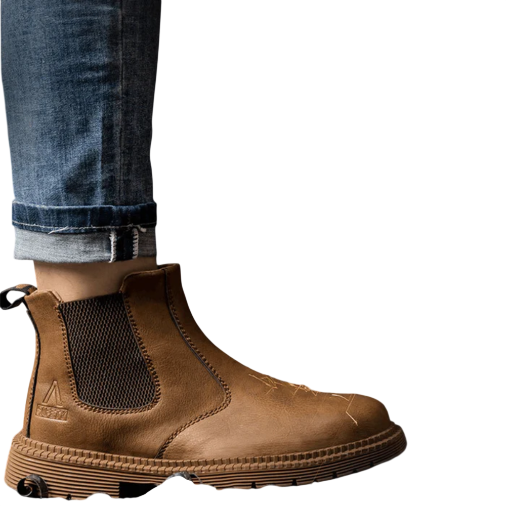 Zbliżenie na osobę w dżinsach i Arkadii Outlet Buty Robocze Męskie Zabudowany Nosek Trwała Konstrukcja stojącą w pobliżu metalowej szlifierki emitującej iskry, z metalowymi wiórami rozsypanymi na podłodze.