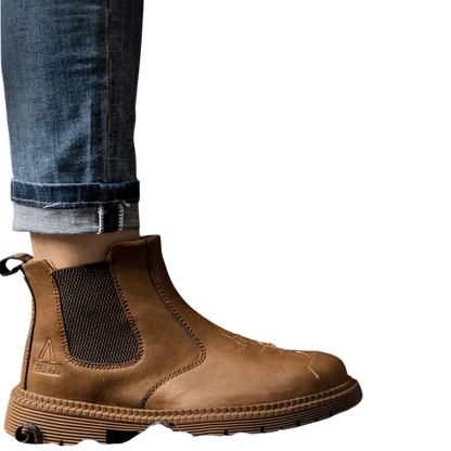 Zbliżenie na osobę w dżinsach i Arkadii Outlet Buty Robocze Męskie Zabudowany Nosek Trwała Konstrukcja stojącą w pobliżu metalowej szlifierki emitującej iskry, z metalowymi wiórami rozsypanymi na podłodze.