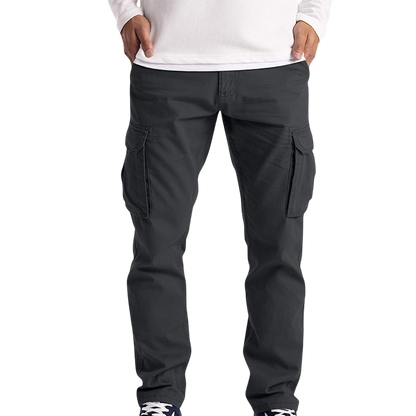 Mężczyzna nosi spodnie cargo męskie luźny krój z kieszeniami na dzień codzienny Arkadya Outlet, w połączeniu z białą koszulą z długim rękawem i ciemnymi trampkami, stojąc na prostym białym tle.