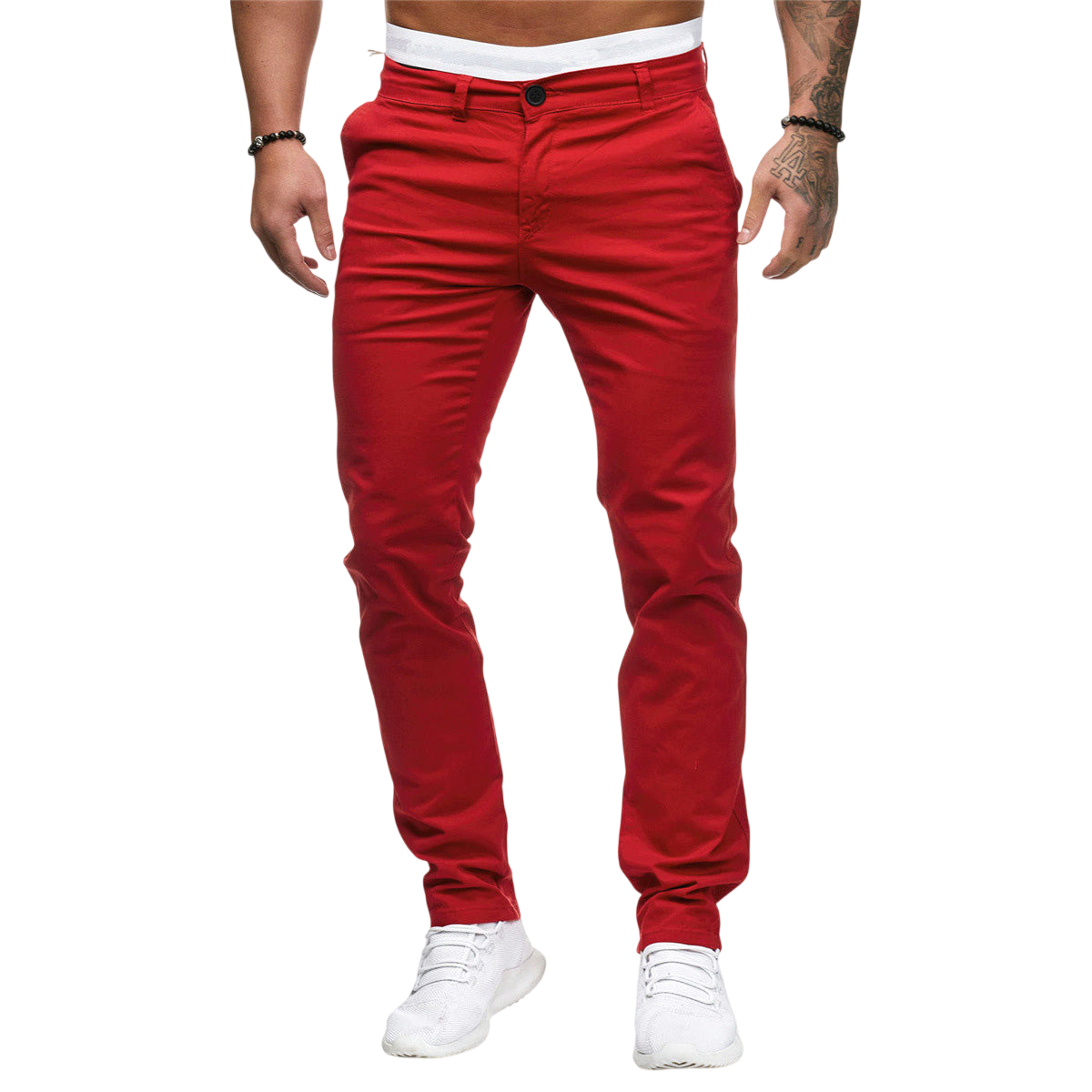 Mężczyzna modeluje Arkadya Outlet Męskie spodnie o dopasowanym kroju i prostej nogawce w kolorze czerwonym, z widocznym białym paskiem w talii i białymi trampkami na jednolitym jasnoszarym tle. Widoczny jest tylko tors i nogi.