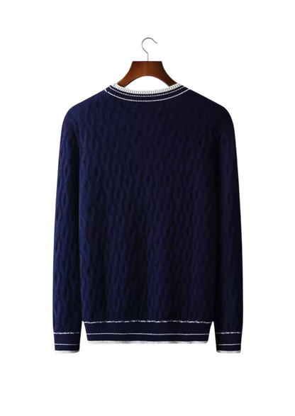 Arkadya Outlet Sweter męski dekolt okrągły kontrastowa lamówka to granatowy sweter z długim rękawem z teksturowanym wzorem i białymi wykończeniami na kołnierzu, mankietach i u dołu, prezentowany na drewnianym wieszaku na białym tle.