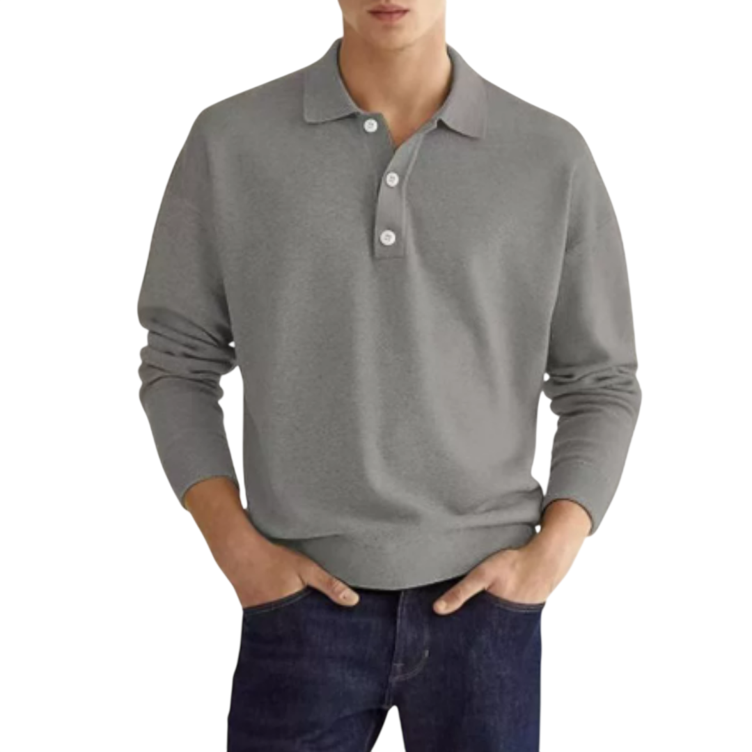 Mężczyzna ma na sobie koszulkę polo Arkadya Outlet Koszulka męska długi rękaw półguziki kołnierz wzór w kolorze jasnoszarym z białymi guzikami i klasycznym kołnierzykiem, w połączeniu z ciemnoniebieskimi dżinsami, stojąc z rękami w kieszeniach na białym tle.