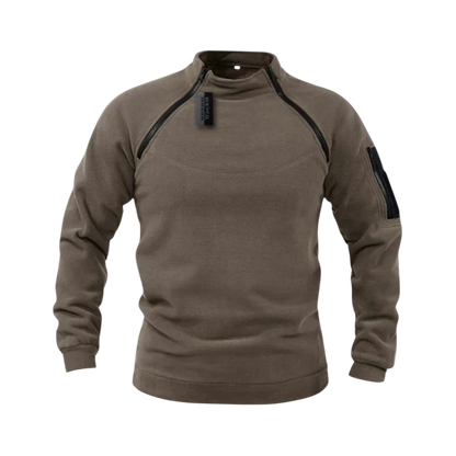 Bluza męska polarowa długi rękaw z kieszeniami Arkadya Outlet w brązowym kolorze, z czarnymi zamkami na ramionach i kieszeniami na lewym rękawie, prezentowana na tle ośnieżonych gór.