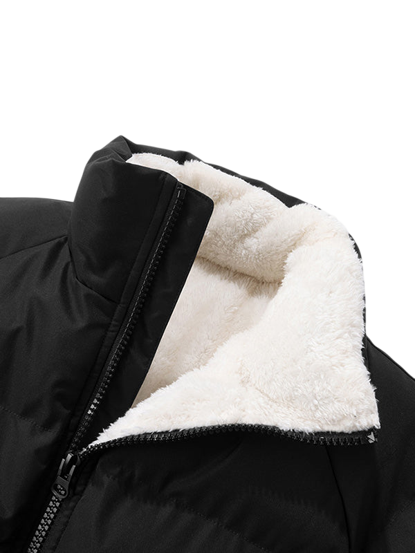 Zbliżenie na Kurtkę Męską Pikowaną Konstrukcja Z Przymocowanym Kapturem marki Arkadya Outlet, z czarnym pikowanym wzorem, widocznym zamkiem błyskawicznym i białym kołnierzem podszytym polarem na jednolitym jasnoszarym tle.