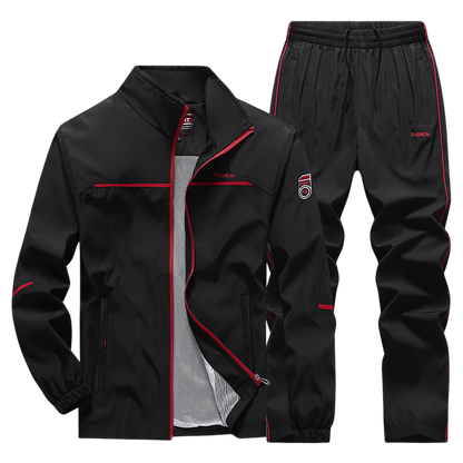 Arkadya Outlet Dres komplet męski dwuczęściowy: czarny zestaw z czerwonymi akcentami, bluza na zamek ze stójką i spodnie na gumce, oba z napisem FASHION na piersi i udzie.