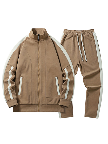 Arkadya Outlet Komplet dresowy męski dwuczęściowy codzienny strój to opalony dres z białymi paskami po bokach, składający się z zapinanej na zamek kurtki i spodni ze ściągaczami, oba z pasującymi białymi akcentami na rękawach i nogawkach spodni.