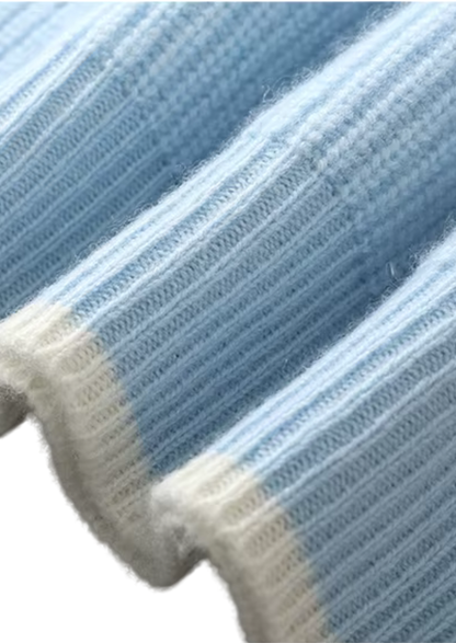 Zbliżenie na jasnoniebieską, prążkowaną dzianinę "Sweter męski dekolt okrągły prążkowana dzianina standardowy krój" marki Arkadya Outlet, z białymi wykończeniami i szczegółową fakturą.