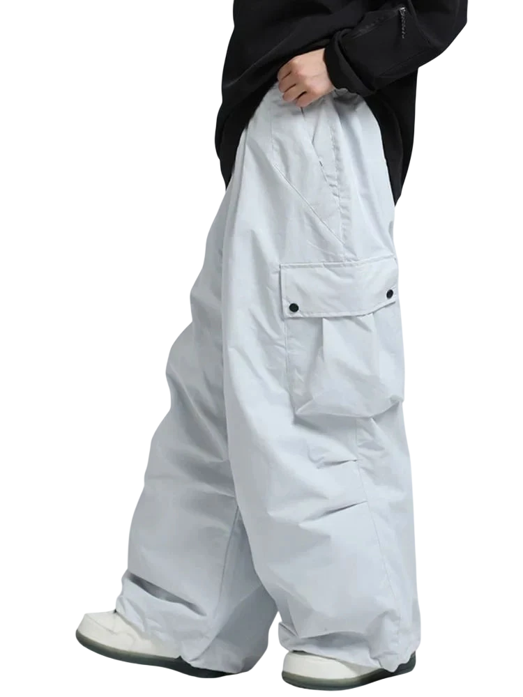 Osoba ubrana w Arkadya Outlet Spodnie zimowe męskie szeroki krój regularny z dużymi kieszeniami i białe trampki, zdjęcie od ramion w dół na jednolitym tle.