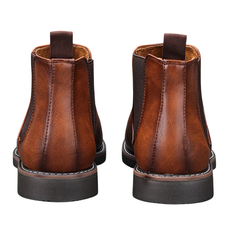 Botki męskie Arkadya Outlet wsuwane sztyblety zimowe w brązowej skórze, widziane od tyłu, z ciemnymi elastycznymi panelami, przeszyciami i uchwytami na pięcie.