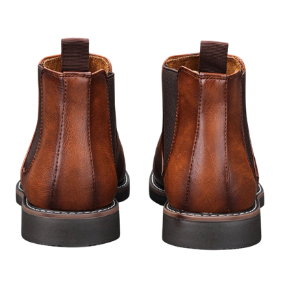 Botki męskie Arkadya Outlet wsuwane sztyblety zimowe w brązowej skórze, widziane od tyłu, z ciemnymi elastycznymi panelami, przeszyciami i uchwytami na pięcie.