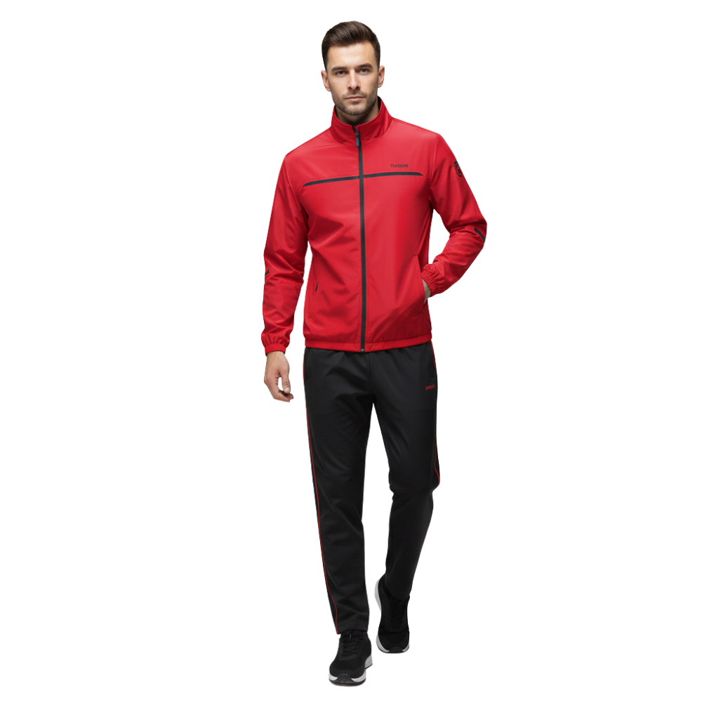 Mężczyzna w Arkadya Outlet Dres komplet męski dwuczęściowy - czerwony bluza na zamek i czarne spodnie w czerwone paski - idzie naprzód z jedną ręką w kieszeni na białym tle.