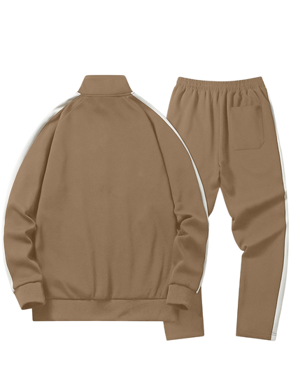 Arkadya Outlet Komplet dresowy męski dwuczęściowy codzienny strój to brązowy zestaw z zapinaną na zamek kurtką i dopasowanymi spodniami, oba w białe paski. Kurtka jest pokazana od tyłu; spodnie mają elastyczny pas i tylną kieszeń.