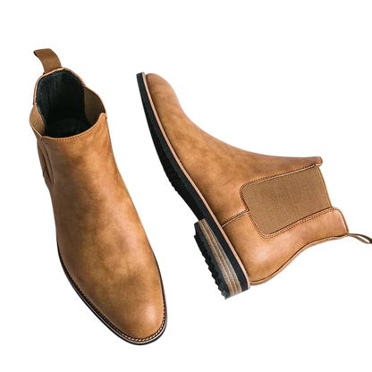 Para tan Arkadya Outlet Botki Chelsea męskie zimowe styl Chelsea na chłód z elastycznymi panelami bocznymi i zakładką do ściągania, pokazana na białym tle - jeden but jest wyprostowany, drugi leży na boku, aby pokazać podeszwę.