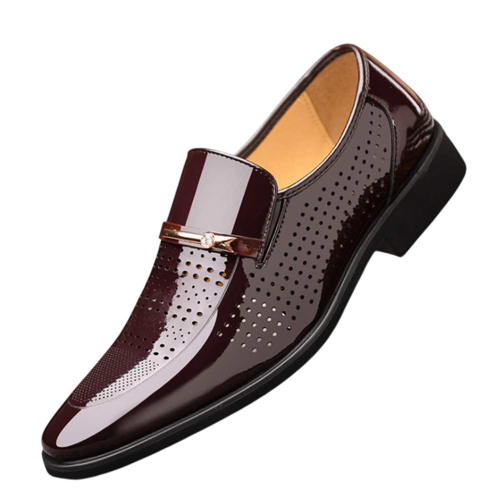Arkadya Outlet Mokasyny Wizytowe Męskie Wsuwany Szpiczasty Nosek to błyszczące ciemnobrązowe wsuwane buty męskie z perforowanymi detalami, złotym akcentem z przodu i niskim czarnym obcasem, pokazane na białym tle.