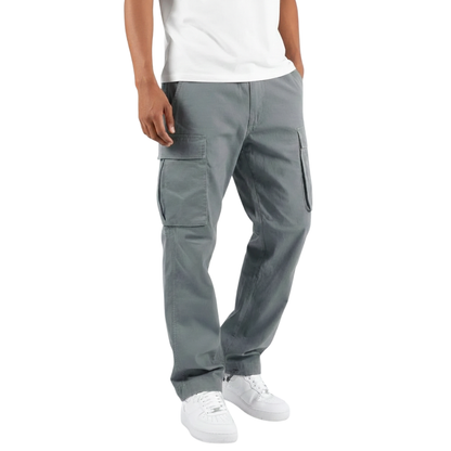 Osoba nosi Arkadya Outlet Spodnie cargo męskie prosta nogawka z wieloma kieszeniami w kolorze szarym, białą koszulkę i białe trampki, stojąc z rozluźnionymi rękami. Obraz jest przycięty na ramionach i stopach.